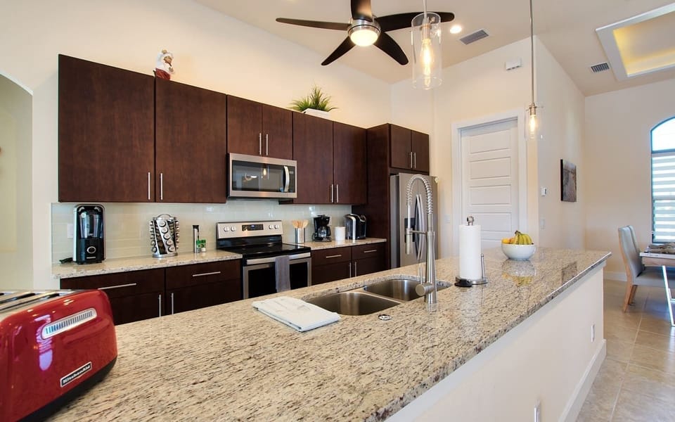 Kitchen detail showing the range, microwave, and dark wood cabinetry with granite countertops