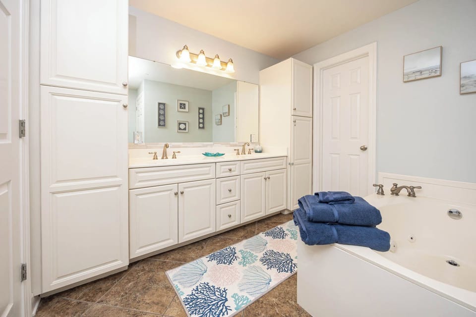 Refresh in the master bath after a day at the beach with a soothing jetted tub and relaxing walk-in shower
