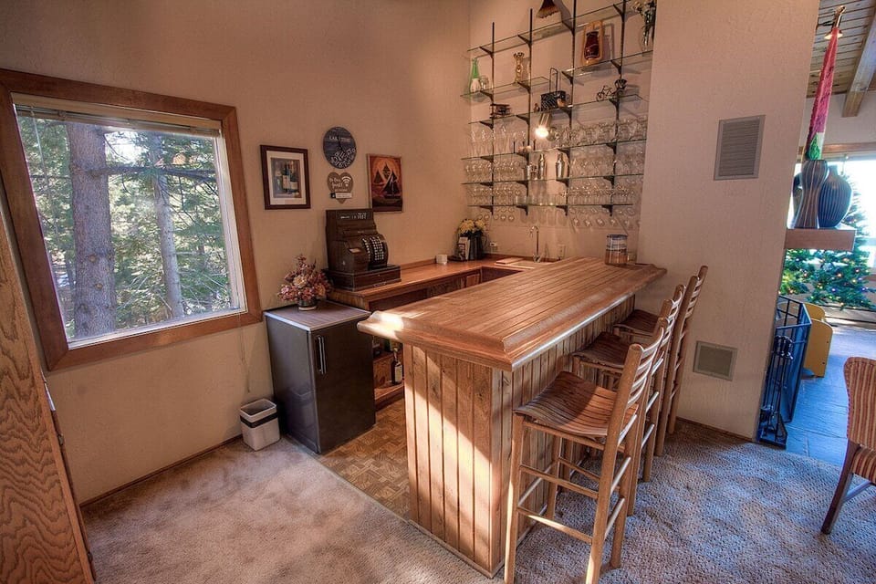 Bar Area with bar stools, bar counter, mini refrigerator, and sink.