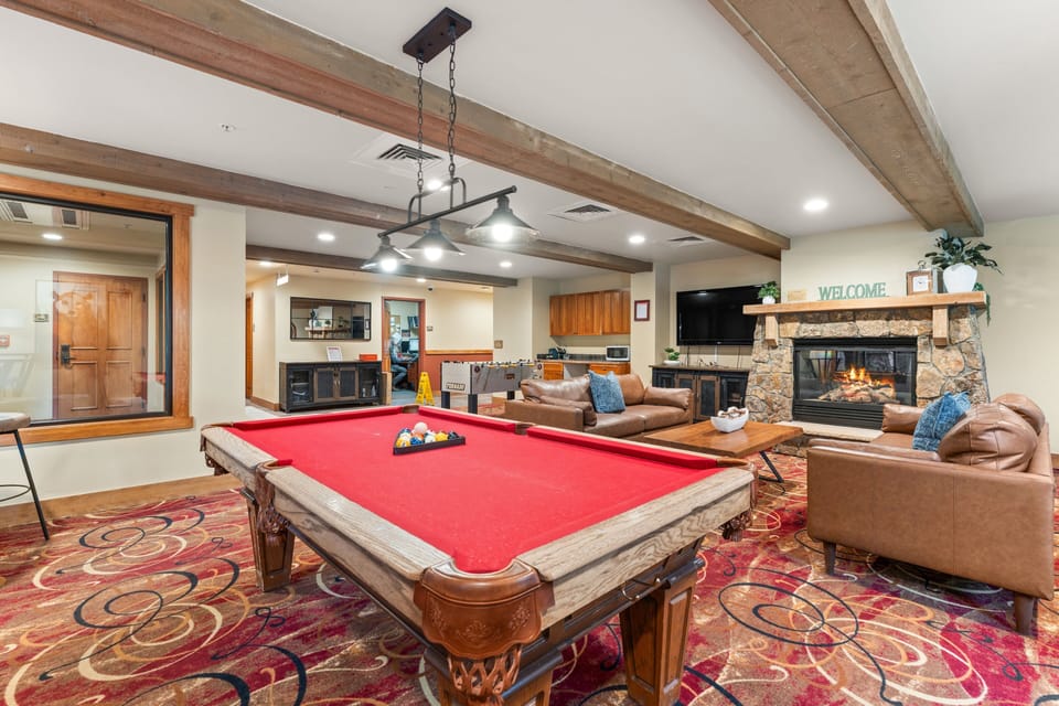 Challenge travel companions to a game of pool in this inviting communal lounge, featuring rustic wooden beams, a stone fireplace, and plush leather seating—the perfect spot to unwind after a day of adventure.