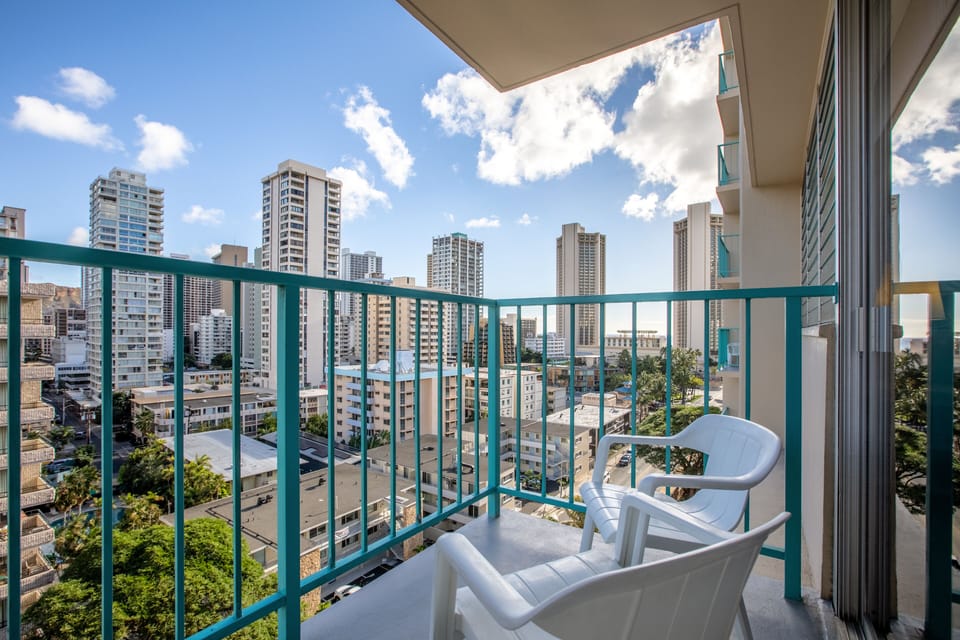 Private balcony overlooking Waikiki's vibrant cityscape—ideal for morning coffee or evening breezes as you take in the urban energy and tropical foliage below.