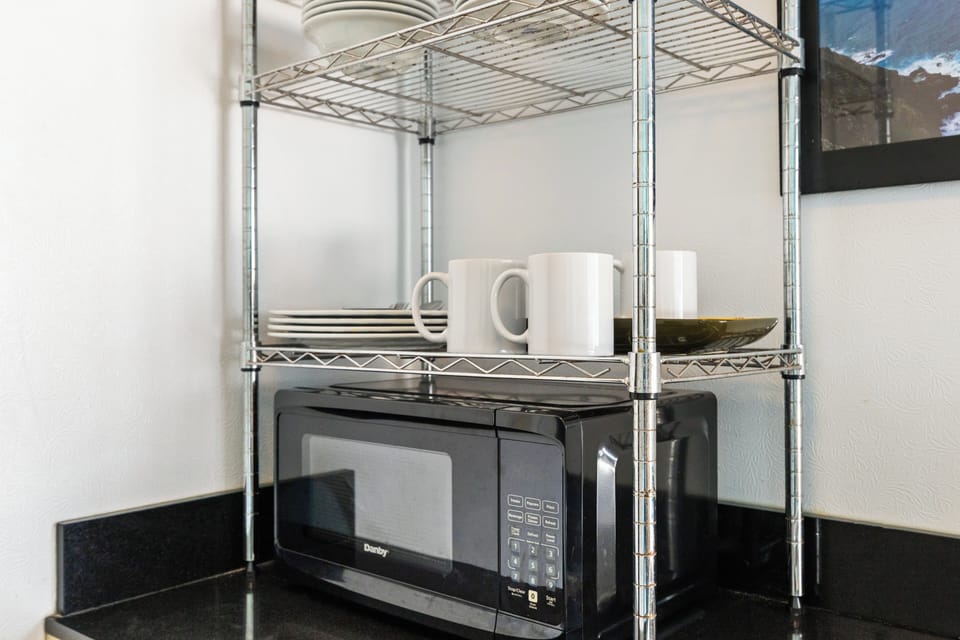 Your kitchenette is stocked with essentials—fresh mugs, plates, and a microwave ready for quick meals. Simple conveniences that make your stay feel effortlessly comfortable.