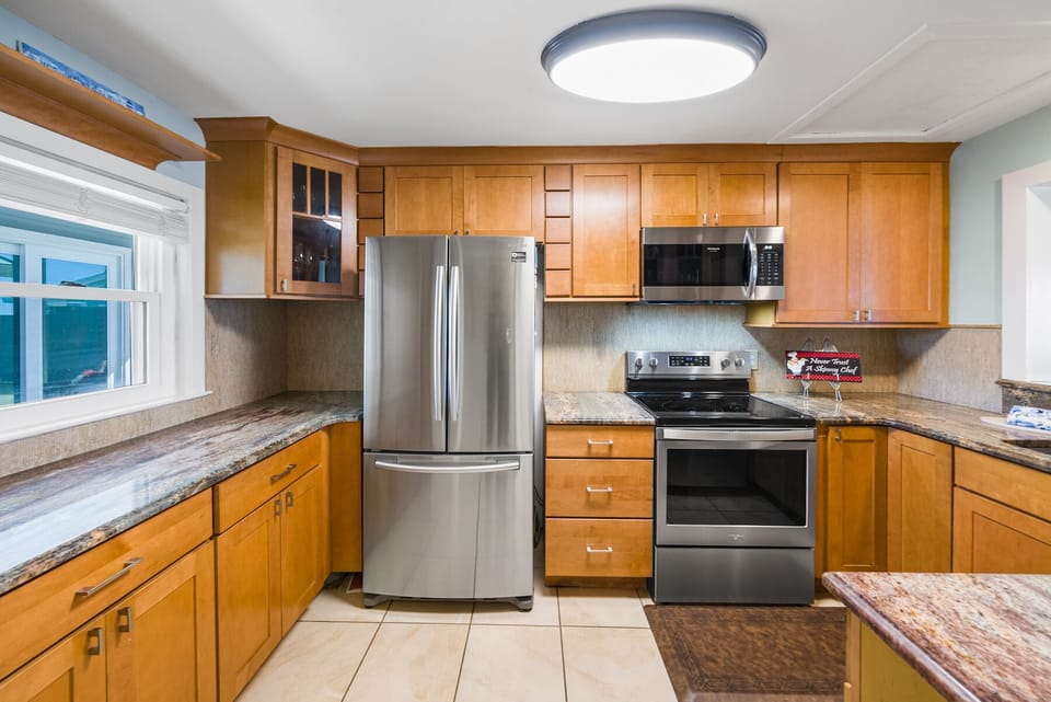 Your fully equipped kitchen features warm wood cabinets, granite countertops, and stainless steel appliances for memorable home-cooked meals.