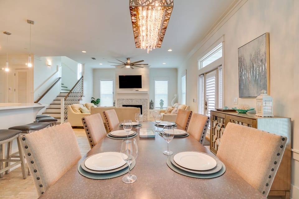 Gather around this elegant dining table where memorable meals await, with sparkling stemware and modern fixtures creating the perfect ambiance.