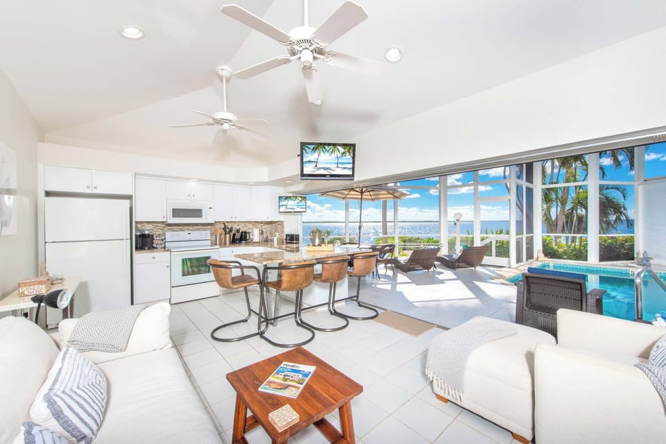 Living area with dazzling water views plus walk-out access to the pool deck.
