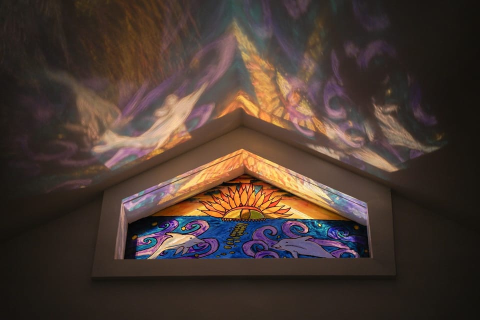 Night light playing through the hand-painted glass window.