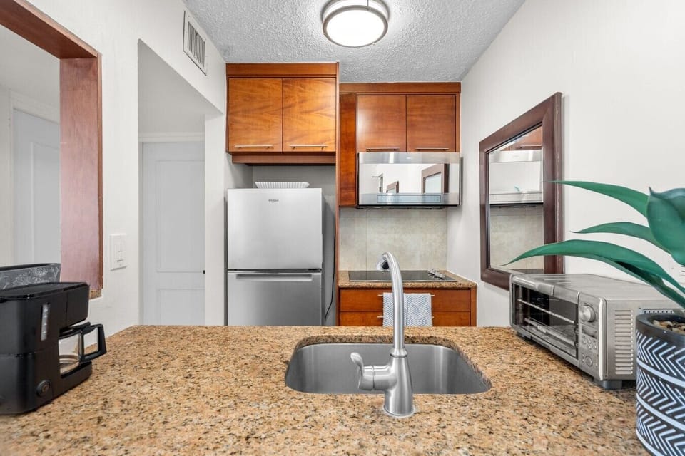Kitchen with refrigerator, microwave, coffee maker, toaster oven, and essentials