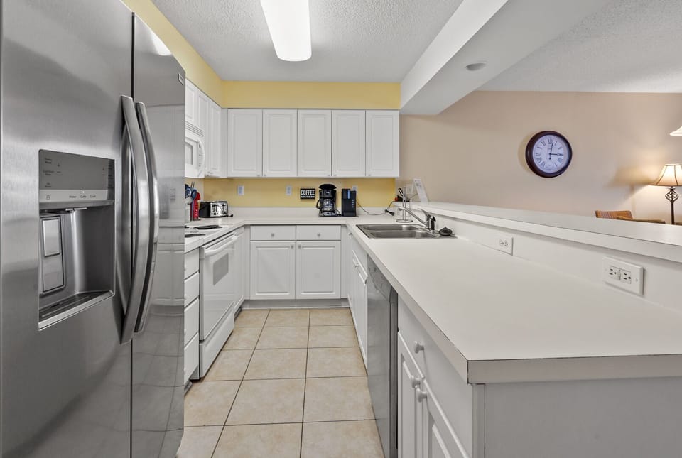 Kitchen with white cabinetry, a coffee maker and roomy counters at Sunrise Pointe 6G, Cherry Grove