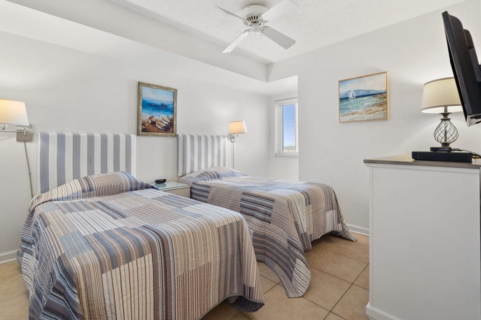 Two beds with striped headboards and sea-themed art at Sunrise Pointe 6G, a 3-bedroom Cherry Grove rental
