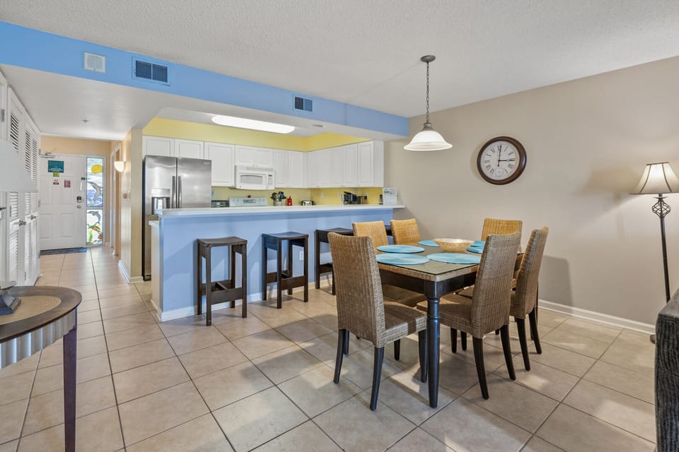 Breakfast bar and dining table with blue and yellow walls at Sunrise Pointe 6G in Cherry Grove