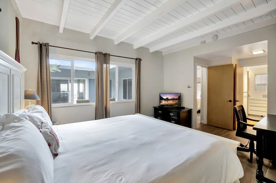 Airy bedroom w/ large windows, soft bedding & a calm, inviting feel