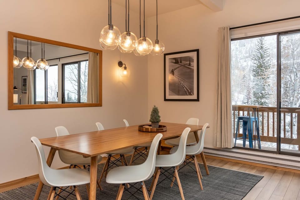 Modern dining area seats eight with surrounding mountain views