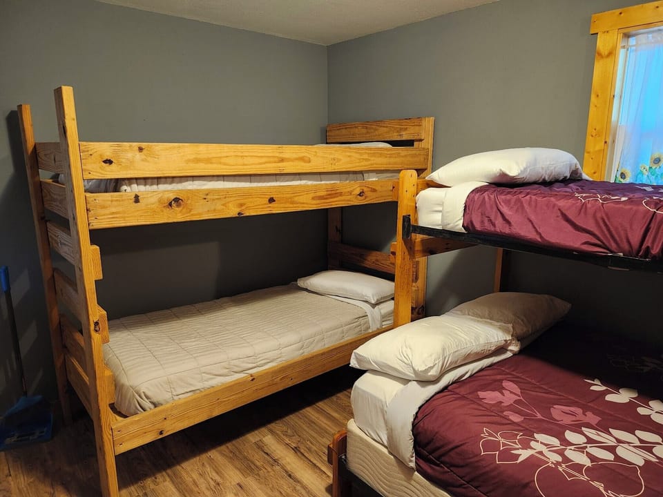 MAIN ROOM:  The main room, which features 6 beds (5 twins and 1 double), a small dining table, and a small sink / kitchenette.