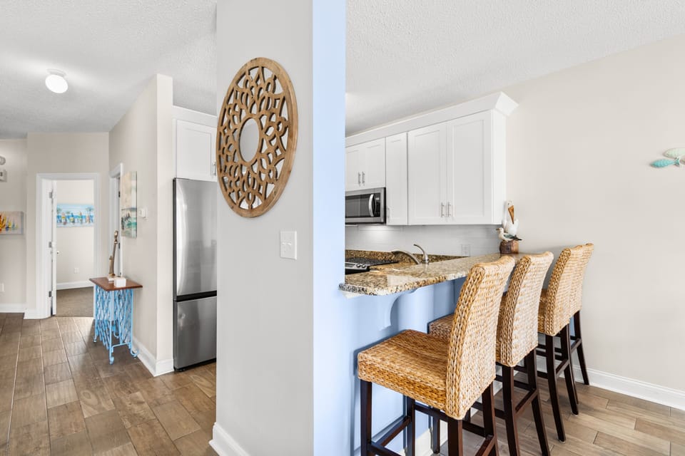 Your modern kitchen features granite counters, stainless appliances, and charming wicker bar seating for casual meals and morning coffee.