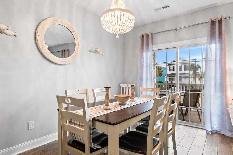 Gather your group around this welcoming dining table, where meals become memories under the soft glow of a stunning chandelier.