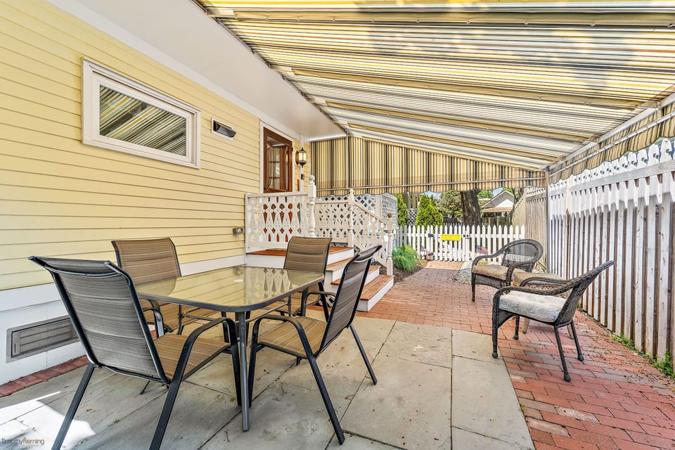Covered porch area with seating & outdoor grill  