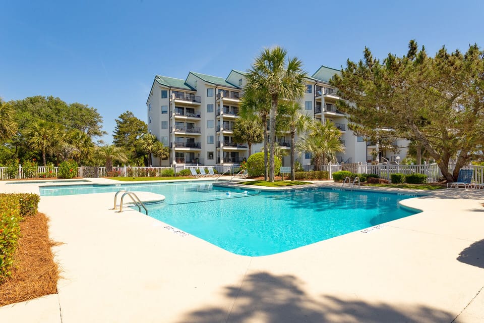 The expansive sun deck provides plenty of space for lounging, while the large swimming pool and adjacent wading area create a perfect setting for families.