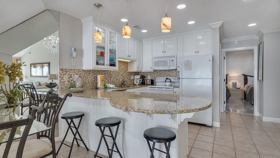 Enjoy the updated kitchen featuring a sleek countertop bar that offers additional seating—perfect for casual meals or gathering with family.