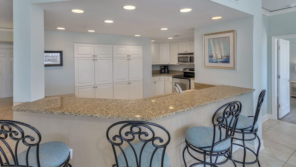 Spacious open-concept design with kitchen island seating and a light-filled living area.