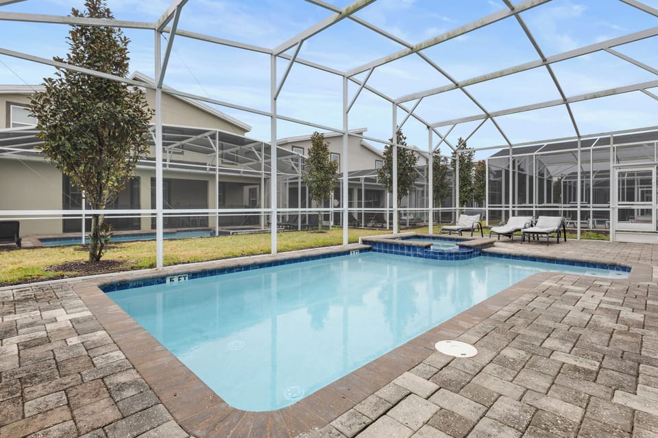 Your private screened pool awaits with sparkling blue water and comfortable loungers, perfect for refreshing swims and sunny relaxation.