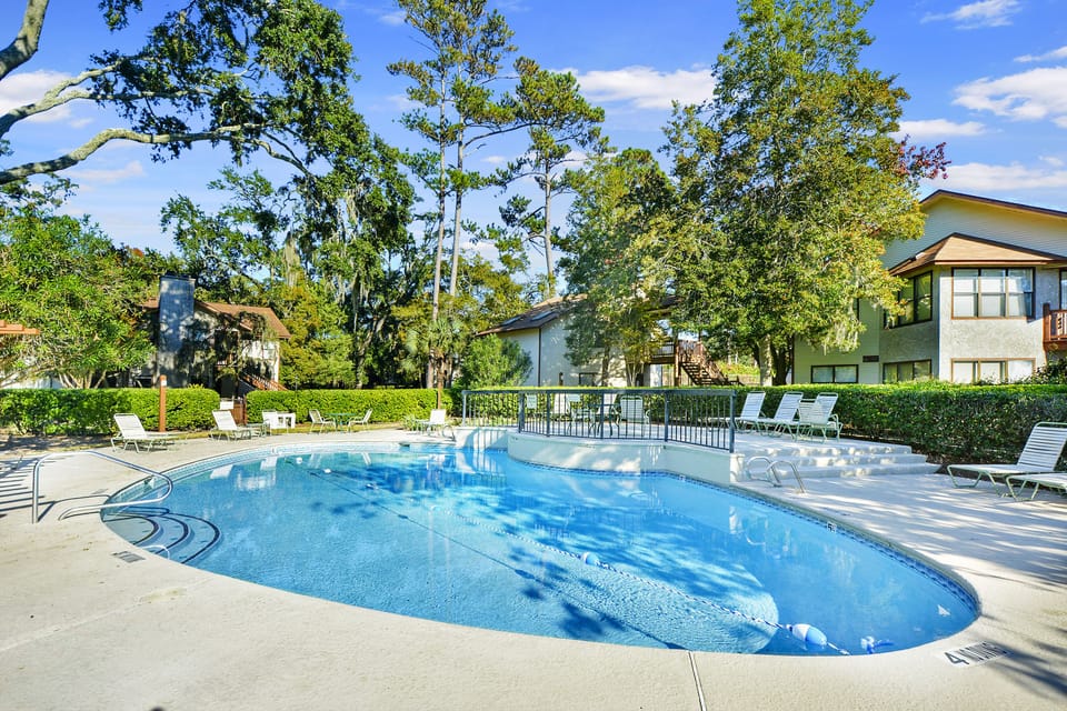 Harbour Oaks Pool – St. Simons Condo Rental - The Harbour Oaks pool, framed by moss-draped oaks and golden light. Just steps from your door at Unit 316—one of the most beautifully updated condos in the Village.