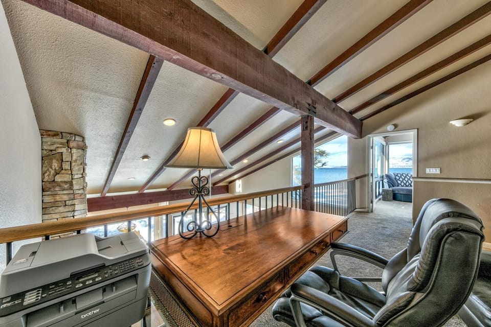 Your private loft office overlooks the main living space, with exposed beams and lake views creating an inspiring workspace.