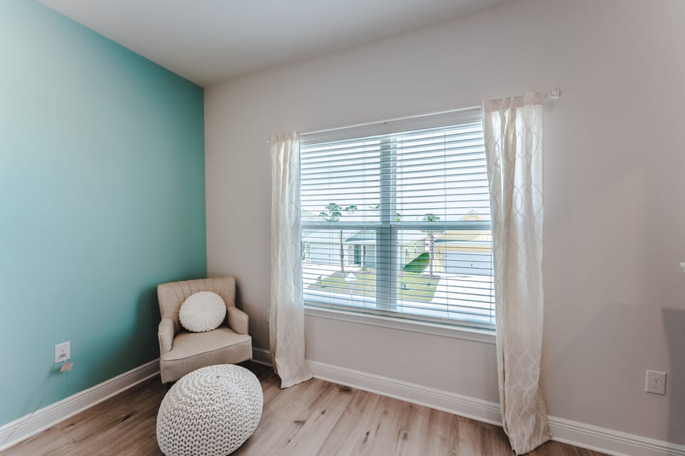 Primary Bedroom with a seating area that has views of the ocean and pool.