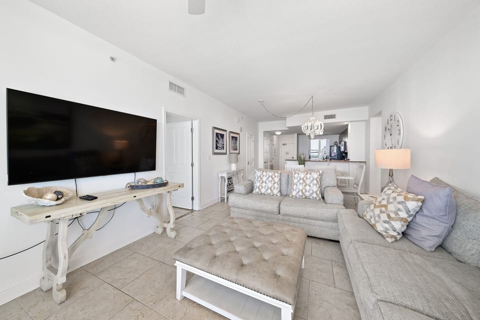 Sink into this elegant living space where soft gray furnishings and coastal decor create your perfect retreat for relaxation.
