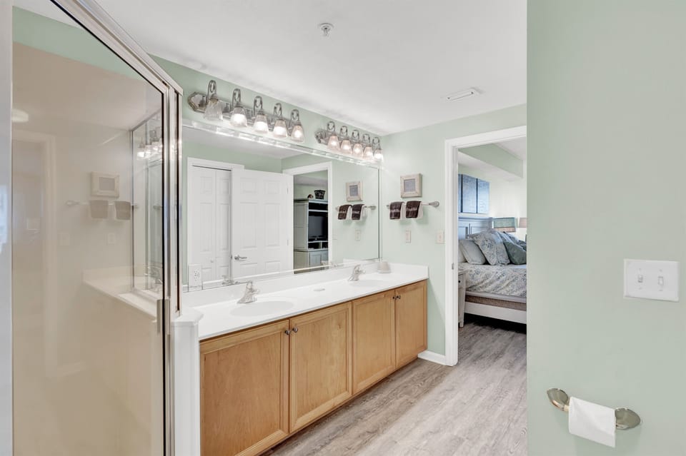 Your spacious master bathroom features dual vanities with elegant lighting, connecting your bedroom and glass shower.