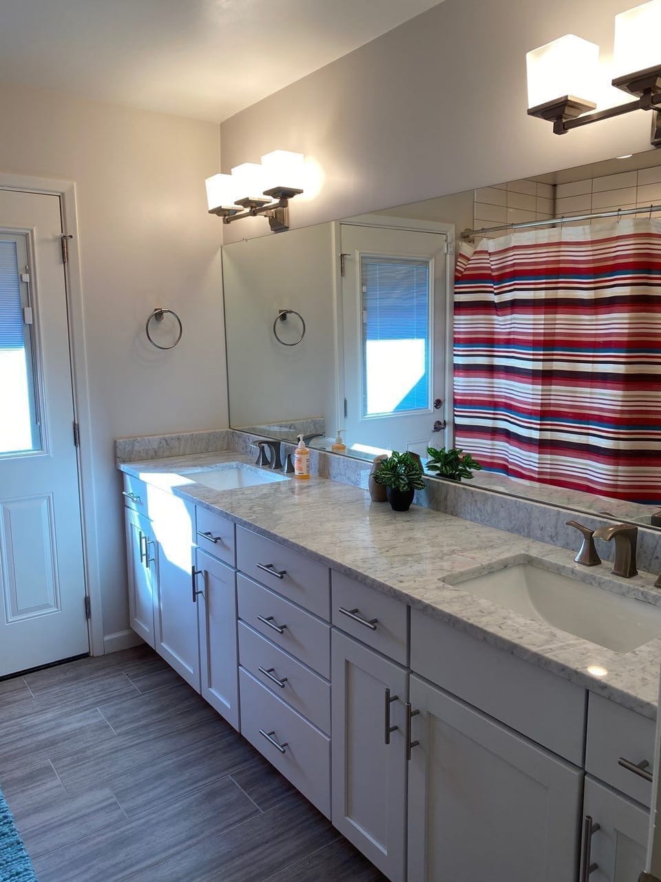 main bathroom.  Dual sinks.  Door connects to outside by pool