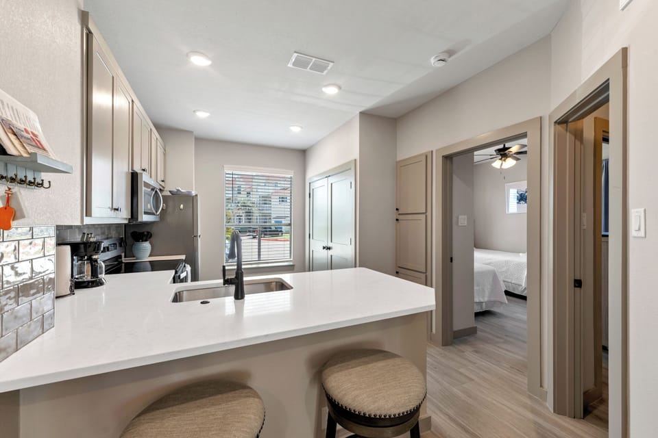 Your modern kitchen awaits with sleek countertops, subway tile backsplash, and bar seating perfect for morning coffee or casual meals together.