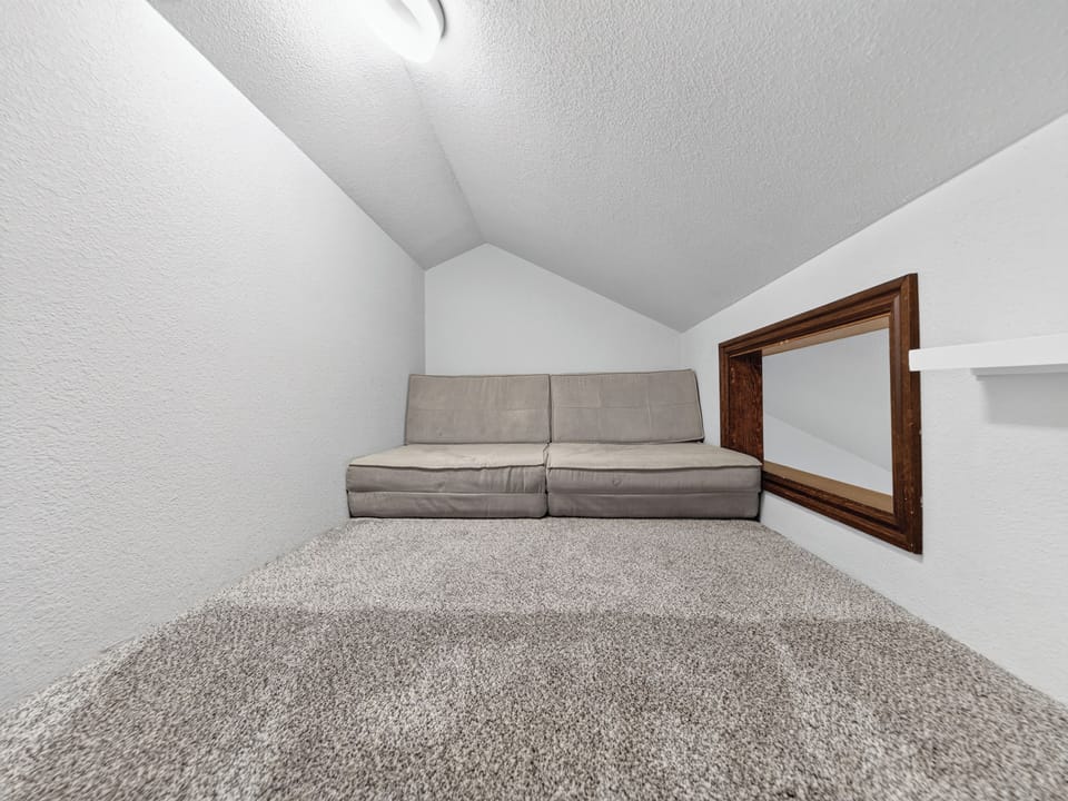 Your private loft retreat features a cozy fold-out sofa and vaulted ceilings, perfect for unwinding after exploring the area or hosting a quiet moment to yourself.