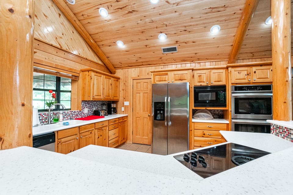 modern conveniences of microwave, dual ovens, stovetop, ice dispensing fridge.