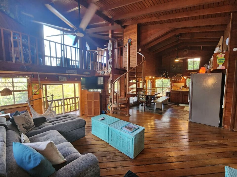 Living room with pull out queen sleeper sofa & queen bean bag chair! Tons of local art pieces decorate the walls to truly set the ISLAND VIBE!