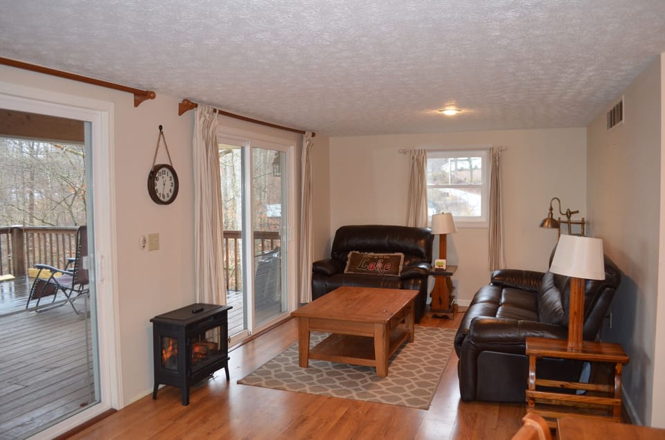 Cozy living room with reclining sofas looking out over the covered porch