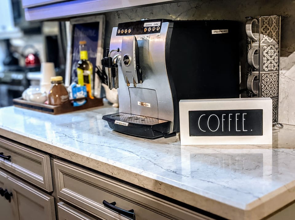 Jura coffee/espresso maker with milk frother upstairs.  Keurig downstairs in bar