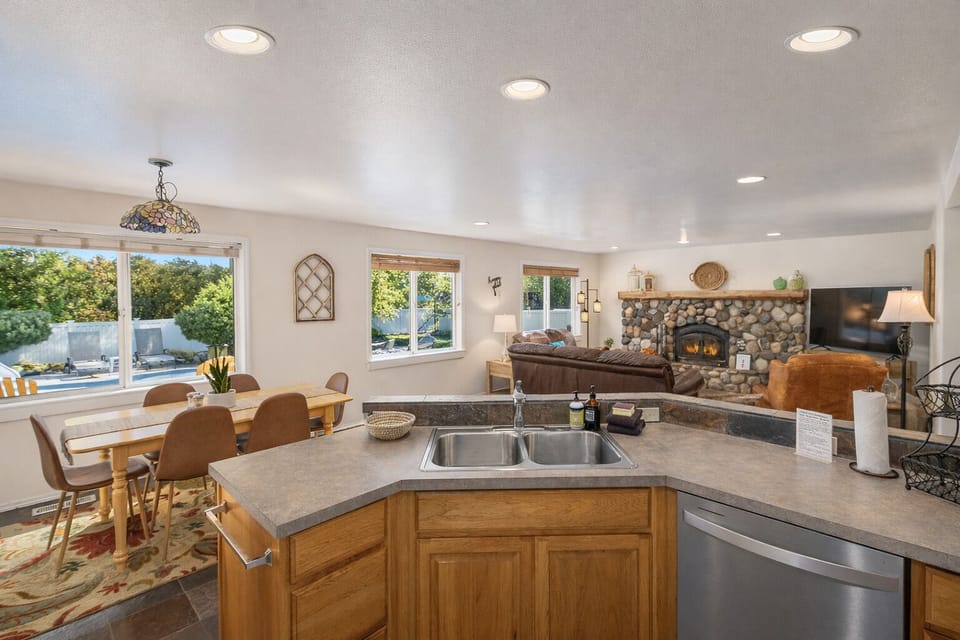 The open kitchen flows into the dining area where natural light streams through windows overlooking the pool, creating a perfect space for gatherings.