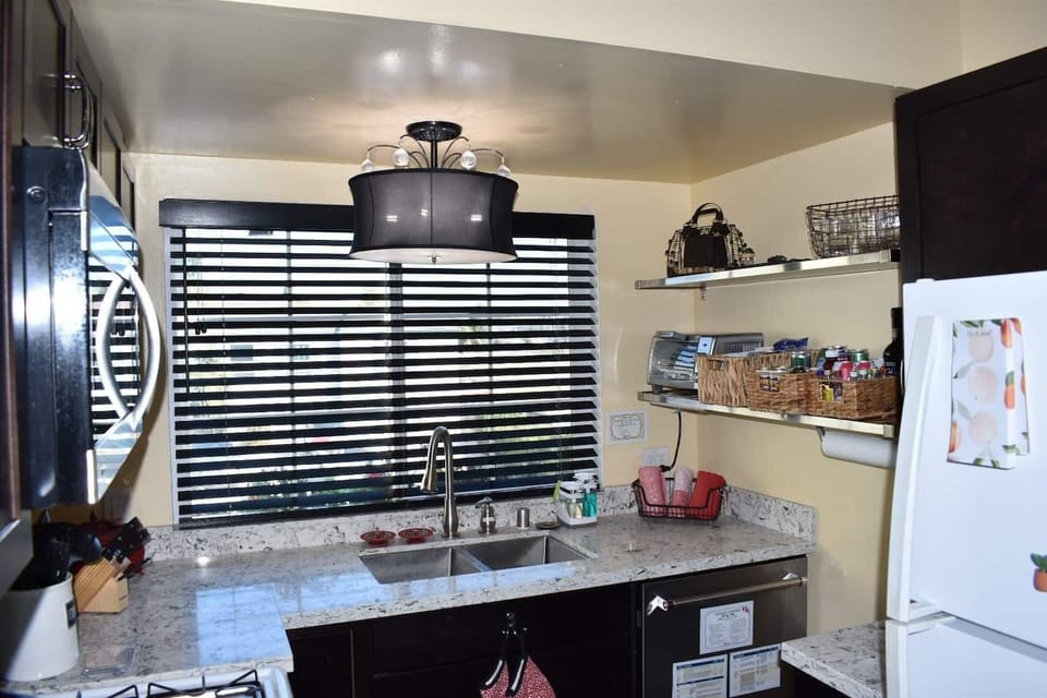 Kitchen view of water (slough) and city lights, dishwasher, full size fridge