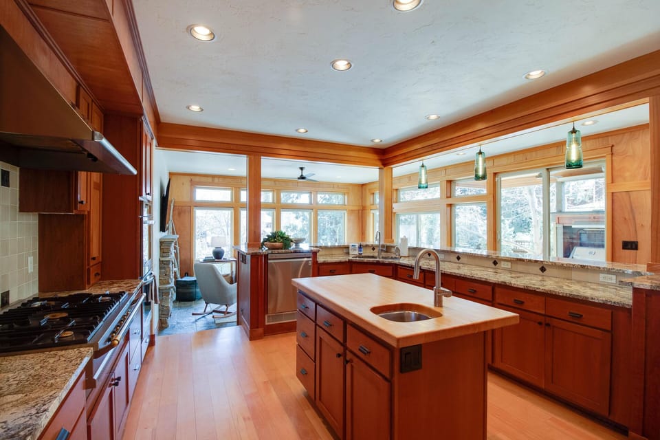 A fully stocked kitchen for gourmet meals at home, complete with French gas stove, on demand hot water, full pantry and bar seating