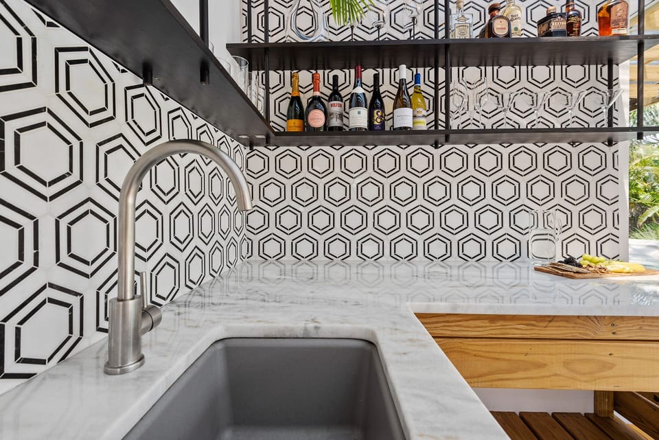 Stunning outdoor wet bar with marble details & custom shelves