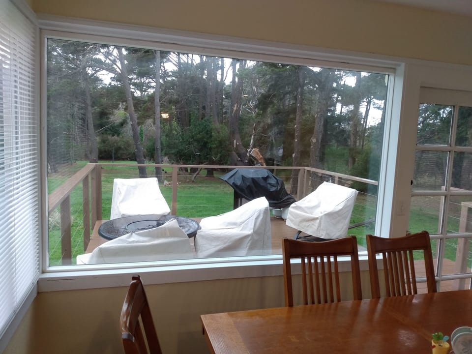 View of deck and large backyard from kitchen. Propane BBQ for guest use.  