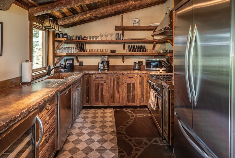 Fully equipped rustic kitchen featuring handcrafted wood cabinetry, modern appliances, and warm beamed ceilings—ideal for preparing your favorite meals in cozy mountain style.