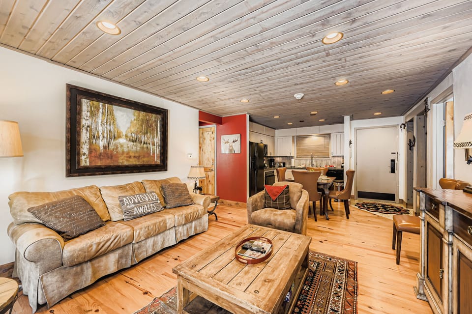Step into your cozy mountain retreat where rustic wood floors and a welcoming living space invite you to unwind after a day exploring nearby trails.