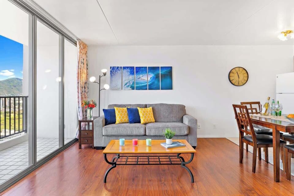 Bright living room with ocean wave artwork and balcony views.