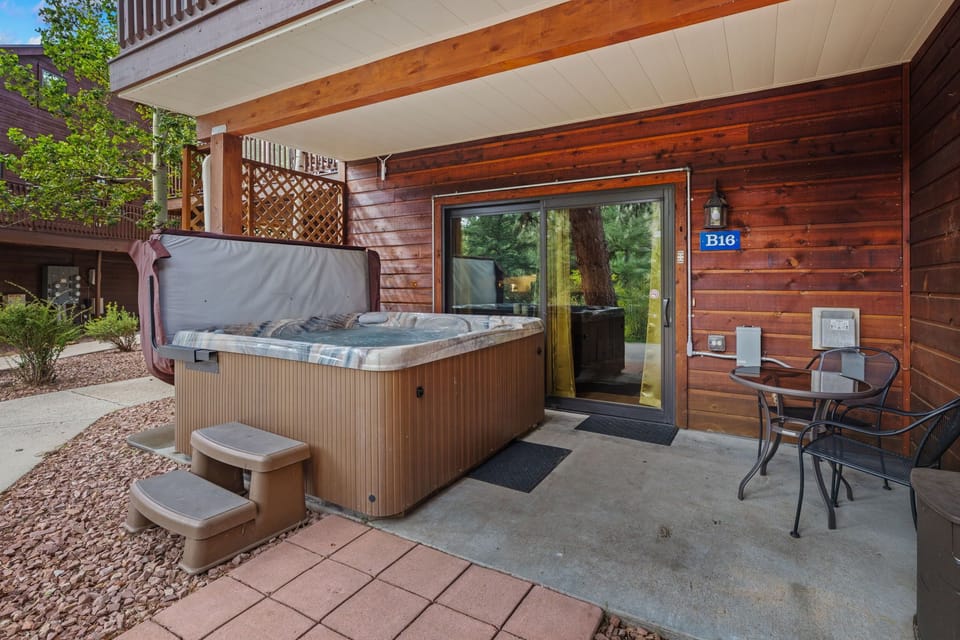 Step outside to your private covered patio where a bubbling hot tub awaits under warm wood beams. Sit at the bistro table with morning coffee or soak under the stars—your personal retreat is ready whenever you are.