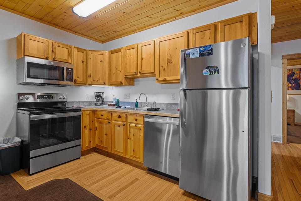 Cook up your favorite meals in this fully equipped kitchen, complete with stainless steel appliances, warm wood cabinetry, and plenty of counter space. Natural light streams through the skylight above, making meal prep feel bright and welcoming.