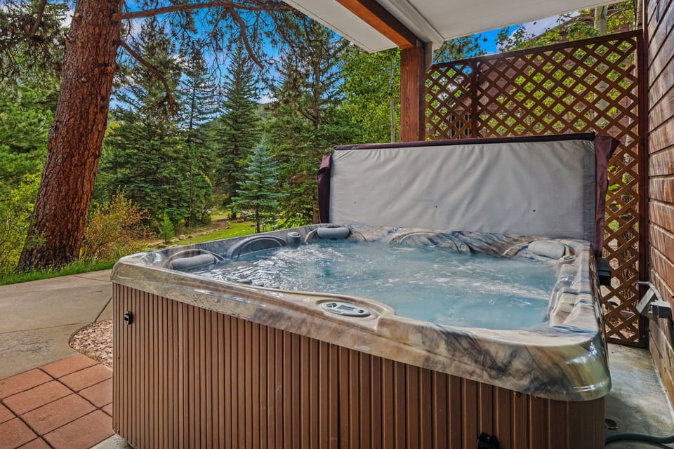 Soak in your private hot tub and let the crisp pine-scented air refresh you while you unwind beneath a towering forest canopy and bright blue skies.