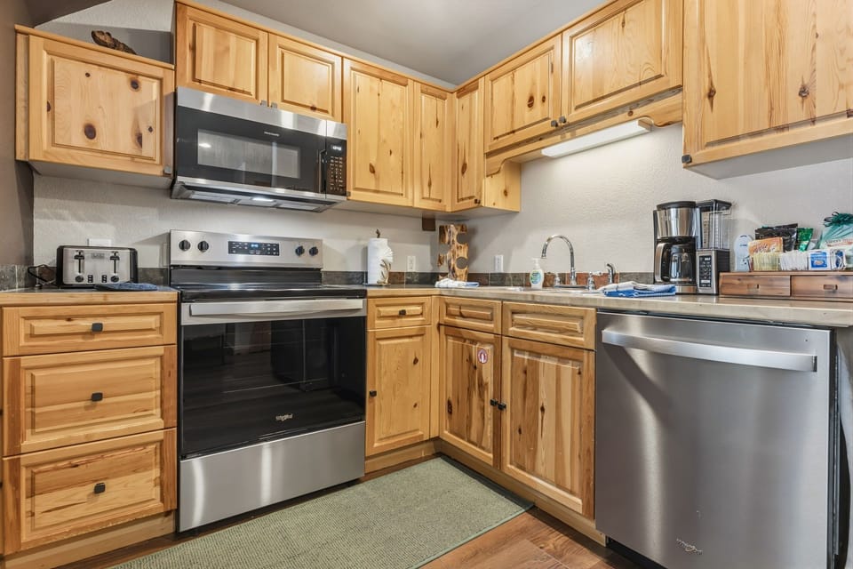 Your fully equipped kitchen features warm wood cabinets and modern stainless steel appliances, perfect for preparing meals during your stay.