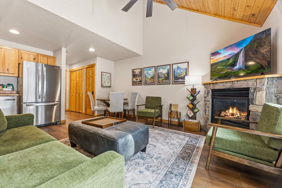 Cozy up by your crackling stone fireplace in this inviting living space, where mountain views and warm lighting create the perfect atmosphere.