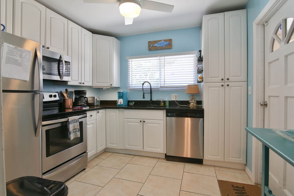 Kitchen with coffee makers, Cuisinart food processor, air fryer, and more.